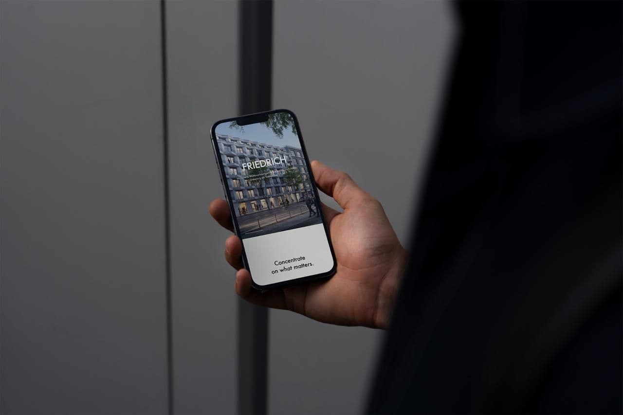 Friedrich App – Smartphone-Mockup mit dem Friedrich-Schriftzug, Fassaden-Render und dem Claim „Concentrate on what matters"